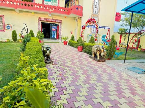 two statues of elephants on a brick walkway in front of a building at Bundeli Farm Resort & Banquet Orchha in Orchha