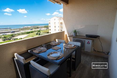 a balcony with a table and a view of the ocean at Vias-Plage - Appartement climatisé avec piscine face à la mer in Vias