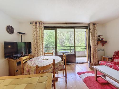 un salon avec une table et une grande fenêtre dans l'établissement Relais S9, à Saint-Jean-dʼAulps