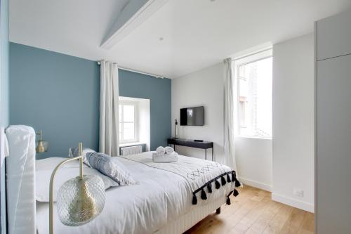 a bedroom with a large bed with blue walls at L'Entre Deux Mers - Belle maison 8 personnes in Dinard