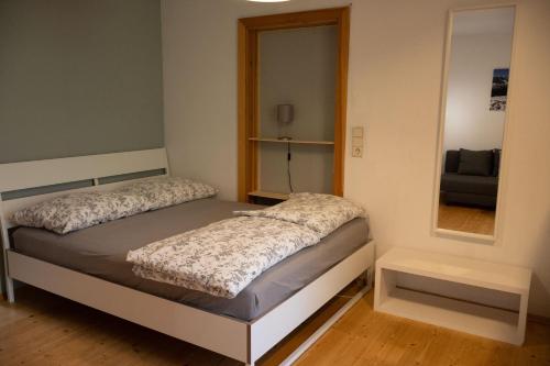 a small bedroom with a bed and a mirror at Haus Irina Zimmer in Kufstein
