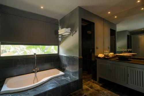 un bagno con vasca e lavandino di Anchan Boutique Resort and Spa a Ban Thalat Choeng Thale