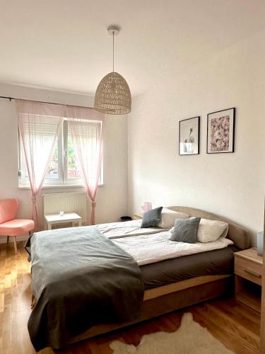 a bedroom with a large bed and a pendant at City Break Apartment in Visoko
