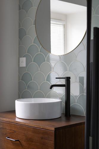 a bathroom with a sink and a mirror on a counter at L'Entre Deux Mers - Belle maison 8 personnes in Dinard