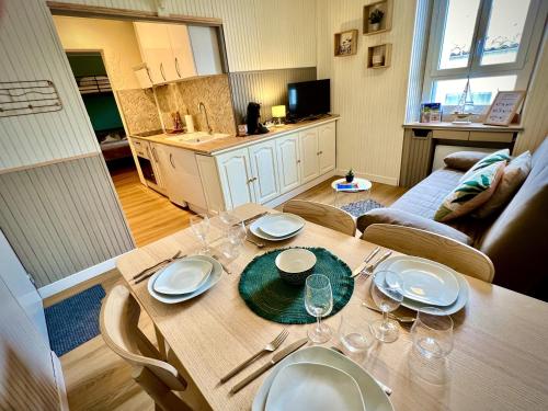 - une table avec des assiettes et des verres dans la cuisine dans l'établissement Appartement remblai 1 chambre Sortie direct plage, à Les Sables-dʼOlonne
