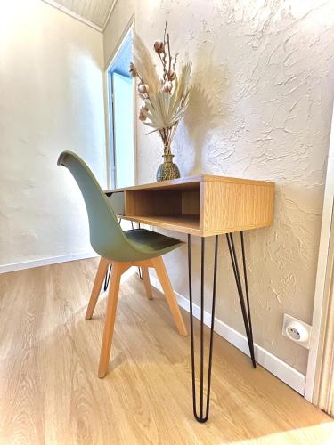 d'un bureau et d'une chaise verte à côté d'une table. dans l'établissement Appartement remblai 1 chambre Sortie direct plage, à Les Sables-dʼOlonne