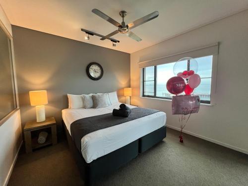 a bedroom with a bed and a window with balloons at Sea Renity at Waterfront - SEAVIEW in Darwin