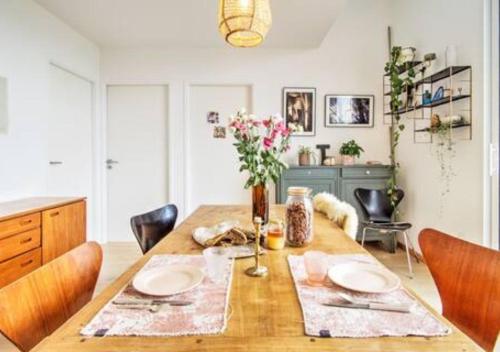 une salle à manger avec une table et des chaises en bois dans l'établissement Appartement lumineux, 6p, toit terrasse, à Montpellier