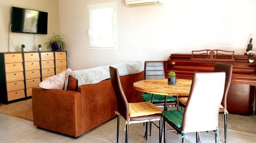 un salon avec un canapé et une table dans l'établissement Maison de village - triangle NIMES - UZES - ALES, à Moussac