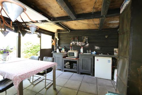 a kitchen with a table and a refrigerator at Vakantie Studio Grou in Grou