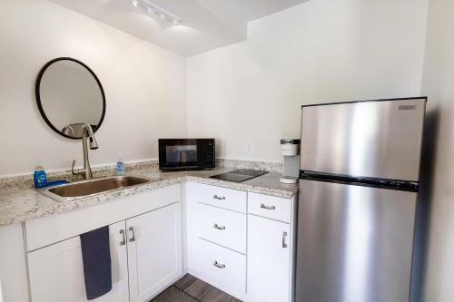 a kitchen with a stainless steel refrigerator and a sink at Anchor Bay Inn and Suites in Sandusky