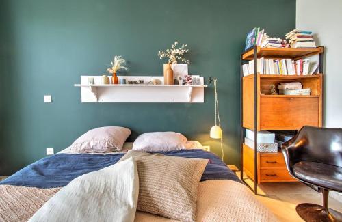 une chambre avec un lit et un mur bleu dans l'établissement Appartement lumineux, 6p, toit terrasse, à Montpellier