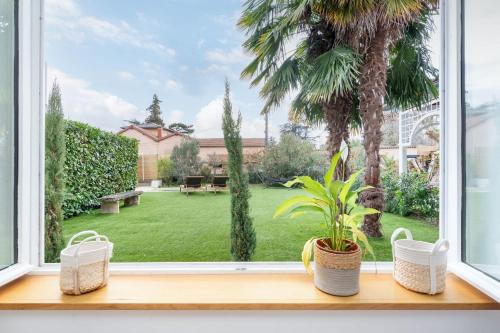 una finestra con vista su un giardino di Louisiane- House with swimming pool a Écully