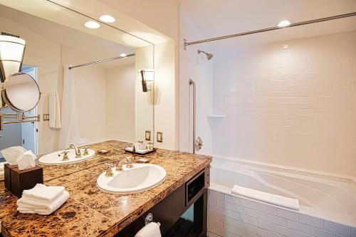 a bathroom with two sinks and a bath tub at Appellation Lodi - Wine & Roses Resort and Spa in Lodi