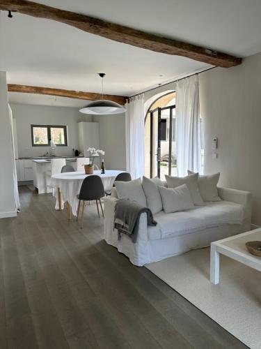 uma sala de estar com um sofá branco e uma mesa em Jolie grange rénovée. em Couches