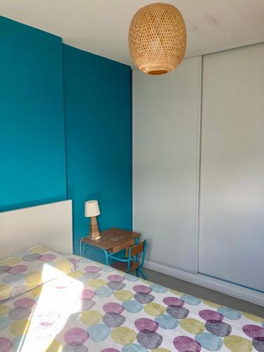 une chambre avec un lit et un mur bleu dans l'établissement Appartement Côte Basque Ciboure Saint-Jean-De-Luz, à Ciboure