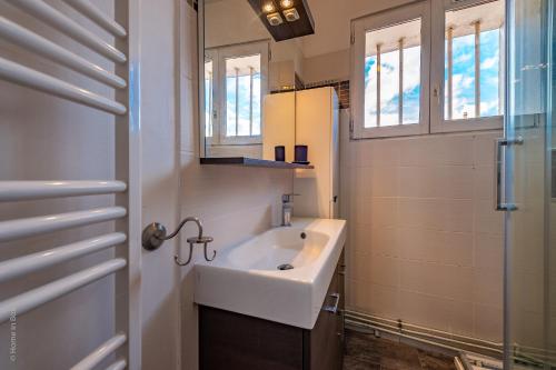 une salle de bain avec un lavabo et un miroir dans l'établissement Maison atypique et familiale, proche Disney avec Wifi, à Chessy