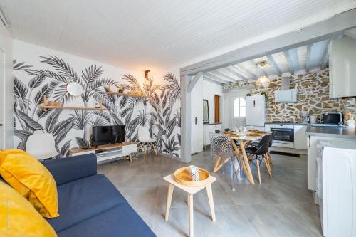 un salon avec un canapé bleu et une cuisine dans l'établissement Maison atypique et familiale, proche Disney avec Wifi, à Chessy