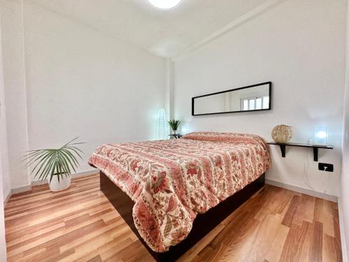 Un dormitorio con una cama y un espejo en la pared. en Sabino Street Apartment, en Santa Cruz de Tenerife