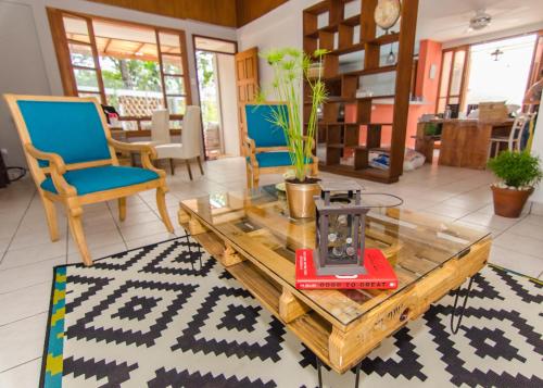 a living room with a coffee table and blue chairs at La Bicicleta Hostal in Managua