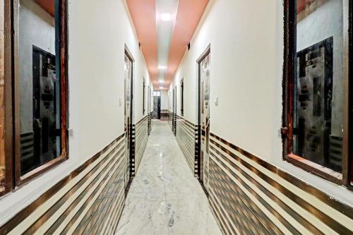 a corridor in a building with marble floors and walls at OYO S S Palace in Agra