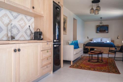 eine Küche und ein Wohnzimmer mit einem Bett im Hintergrund in der Unterkunft Porphyra Studio in Chalki