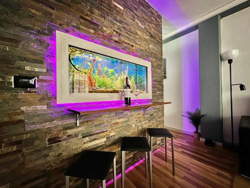 Un bar con luces moradas en una pared de ladrillos. en Sabino Street Apartment, en Santa Cruz de Tenerife