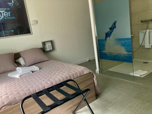 - une chambre avec un lit orné d'une peinture de dauphins sur le mur dans l'établissement Hôtel Le Gambetta, à Vias