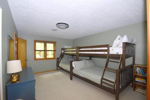 a room with two bunk beds and a lamp at Bobcat 22 -- Hot Tub, Game Room, Wifi, Fire Pit, Pool Access, Fireplace, Grill, Screen Porch, Hiking, Deck, King Bed, Pet Friendly in Berkeley Springs