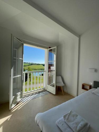 a bedroom with a bed and a balcony with a view at Résidence L'Oustal Del Carlat in Carla-Bayle