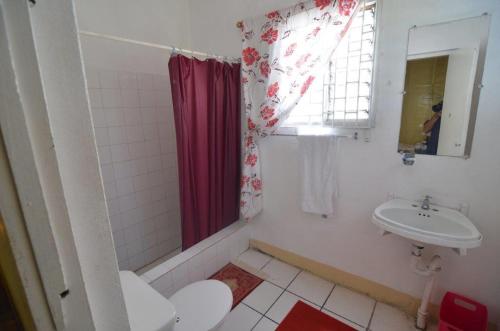 y baño blanco con lavabo y ducha. en Holiday Home - Guest House, en Port Antonio