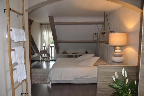 une chambre avec un grand lit blanc dans une pièce dans l'établissement La Villa Séquoia, à Les Bordes-Aumont