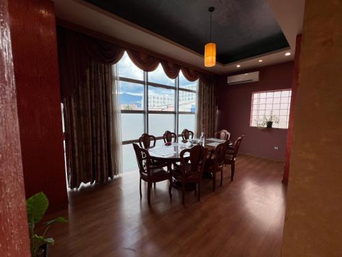 a dining room with a table and chairs and a large window at Apartment 189 in Tirana