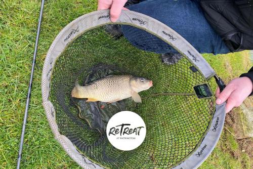 a fish in a net with a person holding a tool at ReTreat Breaks - 47 Park Lane in Patrington