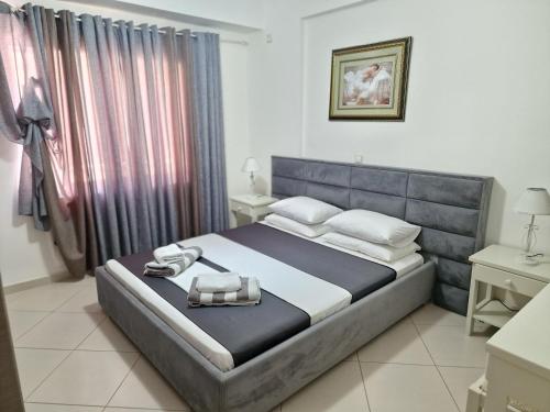 1 dormitorio con 1 cama con cabecero azul en Apartments Saranda, en Sarandë