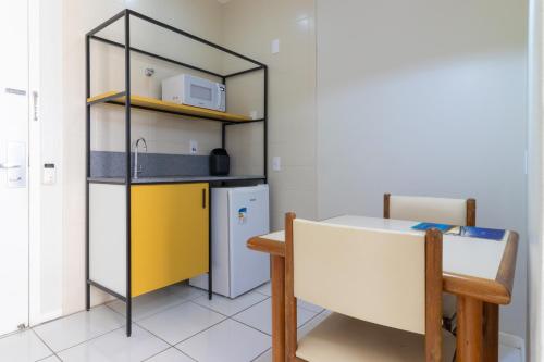 a kitchen with a table and a yellow refrigerator at Rio Branco Hotel in Florianópolis