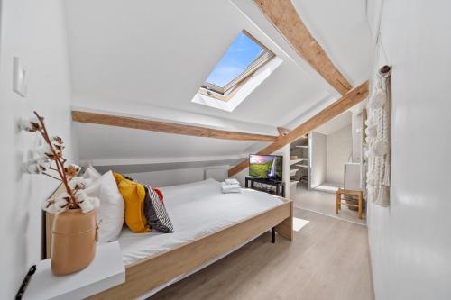 une chambre avec un lit et une fenêtre dans l'établissement Le Vannerie - Appartement cœur historique - Tout équipé, à Dijon