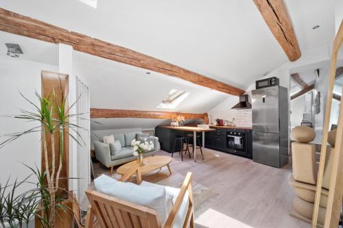 une cuisine et un salon avec un canapé et une table dans l'établissement Le Vannerie - Appartement cœur historique - Tout équipé, à Dijon