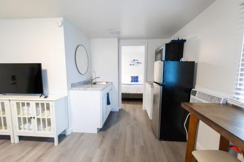a kitchen with a black refrigerator and a sink at Anchor Bay Inn and Suites in Sandusky