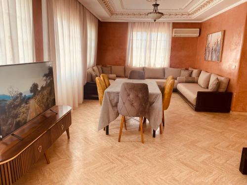 a living room with a table and a couch at Villa Dune Rouge de la Siesta in Mohammedia