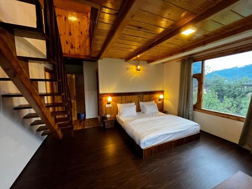 a bedroom with a bed and a large window at THE LANDSBY COTTAGES in Nagar
