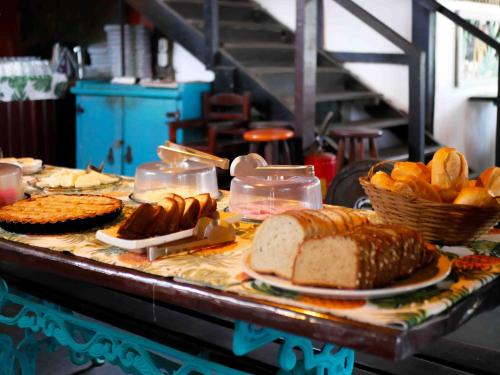 een buffet met brood en andere voedingsmiddelen op tafel bij Hostel Sereia do Mar in Paraty