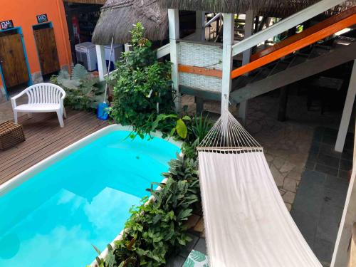 a swimming pool with a hammock next to a house at Hostel Sereia do Mar in Paraty