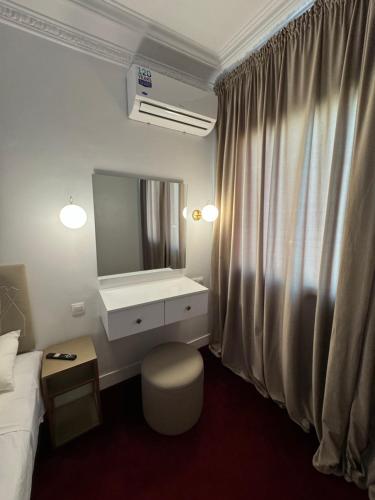ein Schlafzimmer mit einem Bett, einem Waschtisch und einem Spiegel in der Unterkunft Crystal boulevard in Tangier