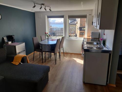 cocina y sala de estar con mesa y sillas. en FeelHome small 1 bedroom apartment Polar vegen, en Tromsø