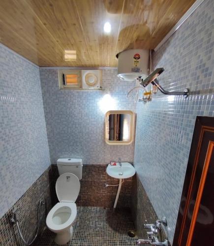a small bathroom with a toilet and a sink at cocostay coorg in Madikeri
