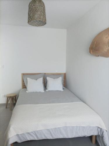 une chambre avec un lit avec deux oreillers blancs dans l'établissement Appartement avec piscine, à Sète
