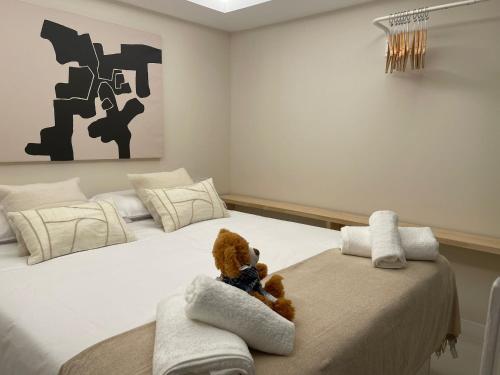 un osito de peluche sentado en una cama en un dormitorio en Osito Hub - Poeta Durán, en Valencia