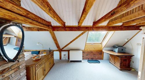 a attic room with wooden ceilings and a mirror at Haan-Ferienwohnung in Haan