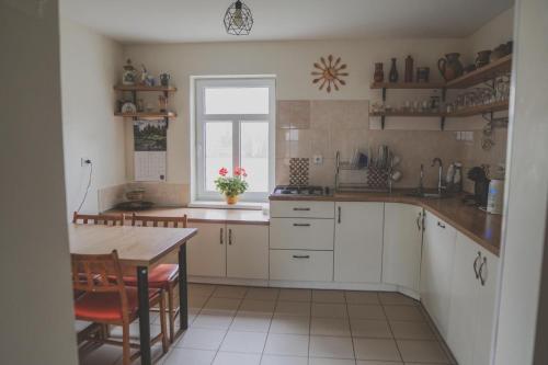 a kitchen with white cabinets and a table and a window at Aimasas in Soleimi